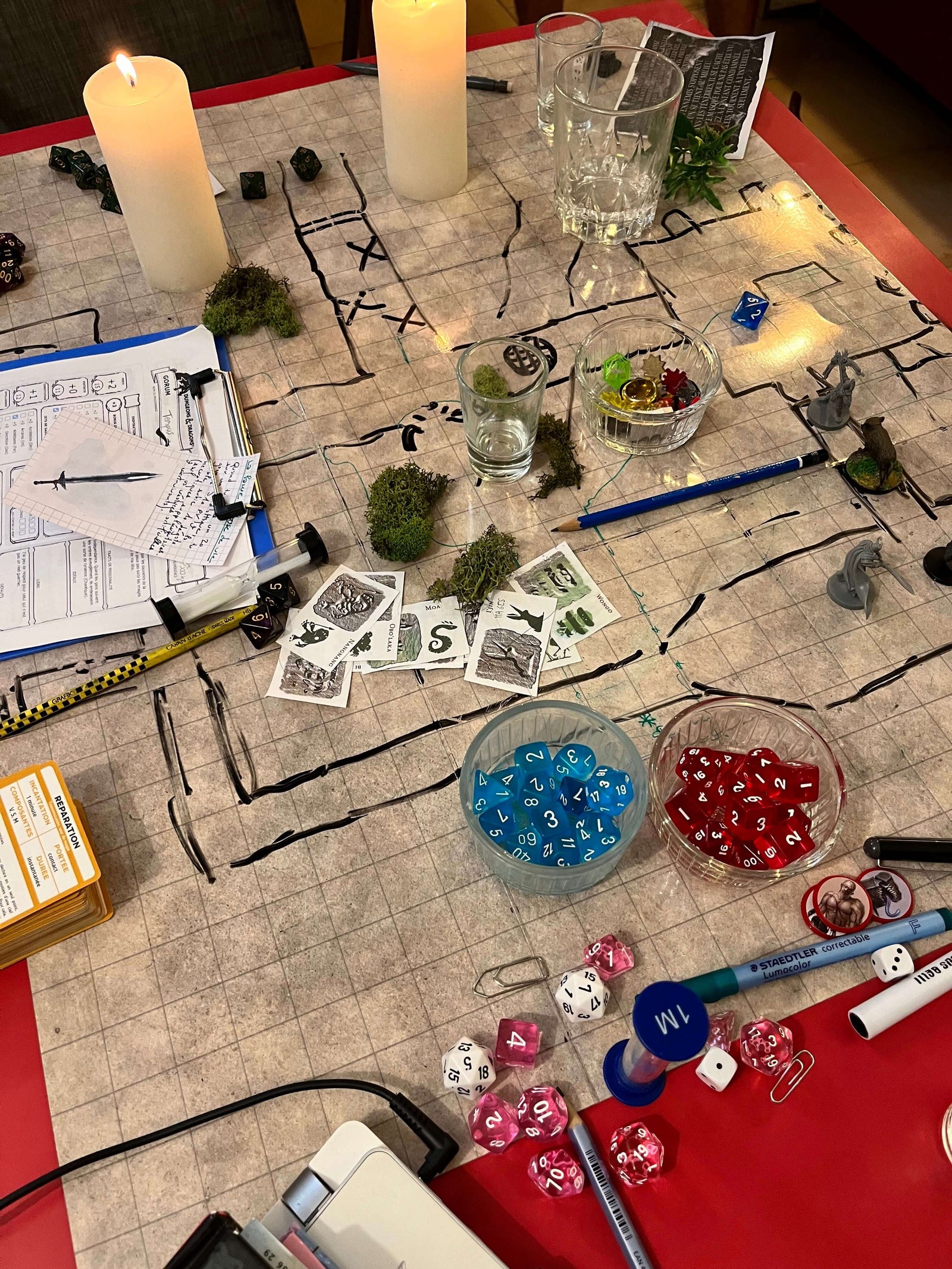 une table de jeu de rôle avec battlemap, bougies décors dés et figurines